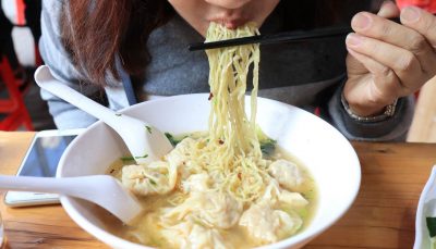 Woman eating Hong Kong-style wonton soup